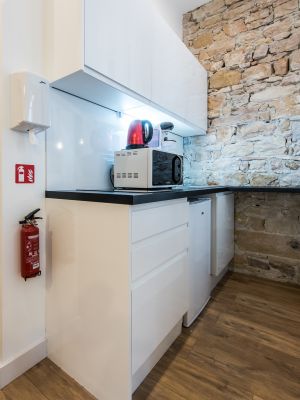 Cuisine sans poignée, mur en pierres apparentes